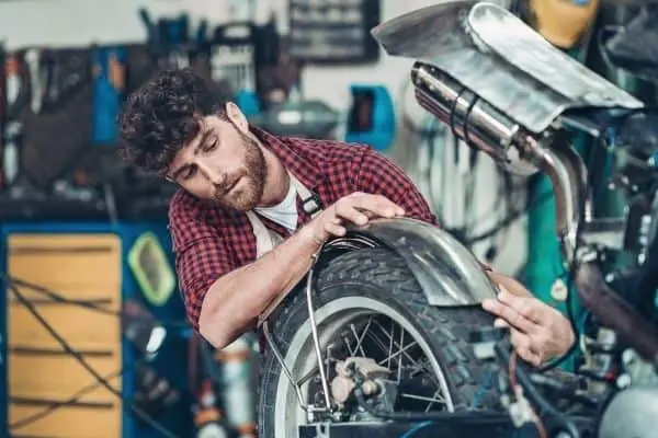 A Man Repairing Motorcycle In Garage