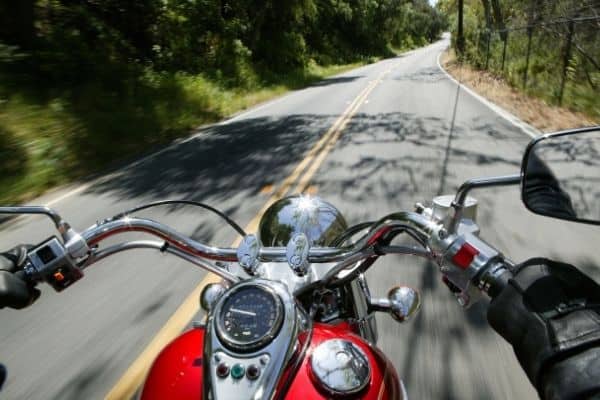 Person Riding Red Cruiser Motorcycle In Open Road