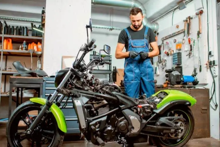 Man Is Fixing His Motorcycle In Garage