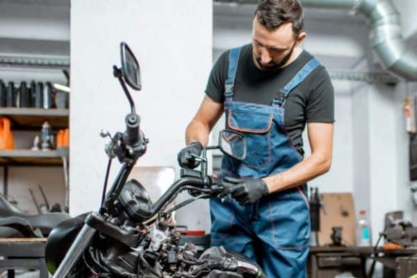 Mechanic Checking Handlebars Of Motorcycle
