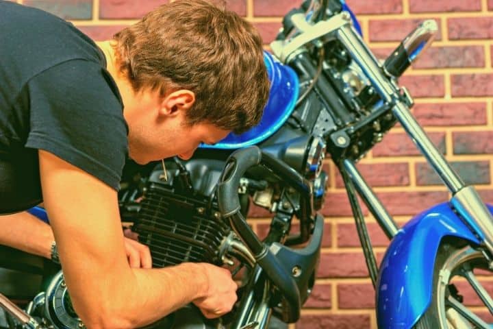 A Man Is Fixing A Motorcycle