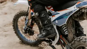 Biker With A Knee Protector Riding A Dirt Bike