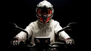 Motorcycle Rider Wearing A Helmet And A Hoodie Against A Black Background