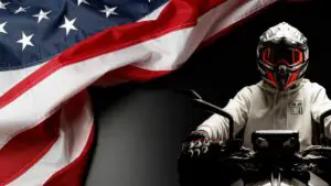 A Motorcycle Rider Wearing A Helmet Against A Black Backdrop With American Flag