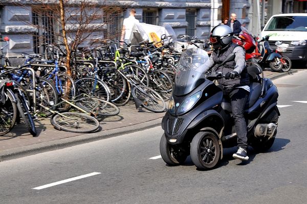 A Motorcyclist In Helmet Riding Piaggio Mp3 500