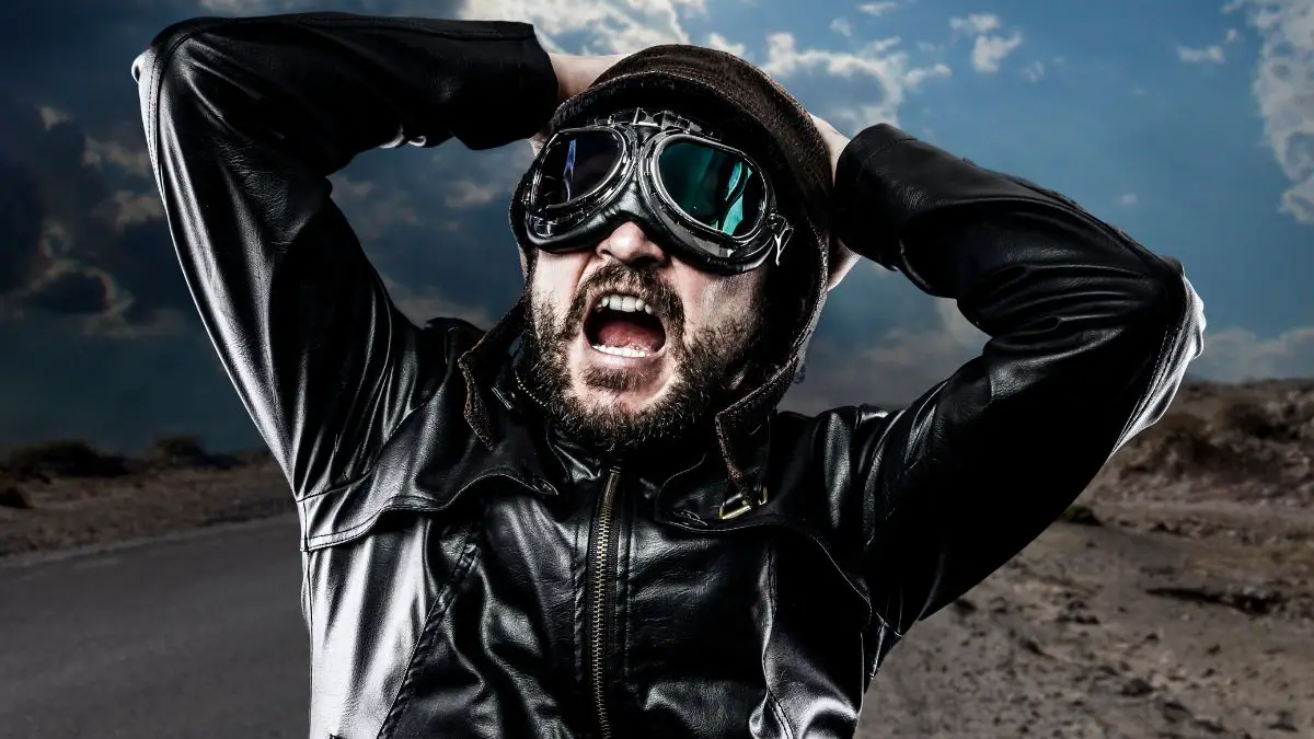 A Surprised Biker Wearing Black Leather And Goggles