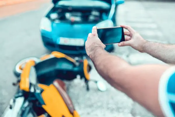 A Man Taking Photos Of A Car And Motorcycle Accident