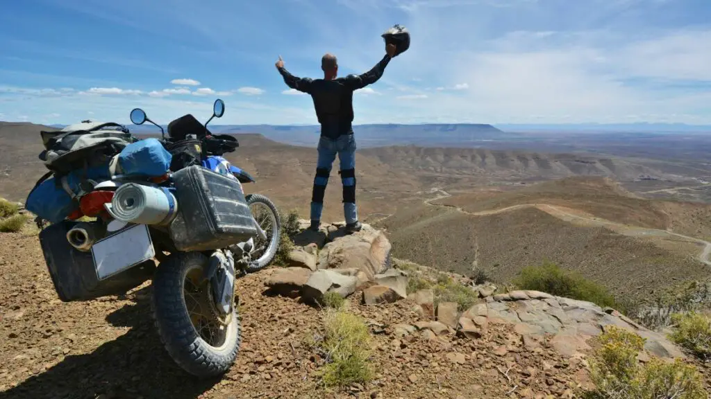 A Triumphant Motorcycle Rider Standing On A Hill In Karoo, Africa